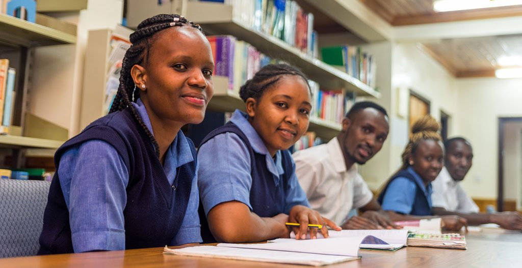 Students in college uniform studying together in the library